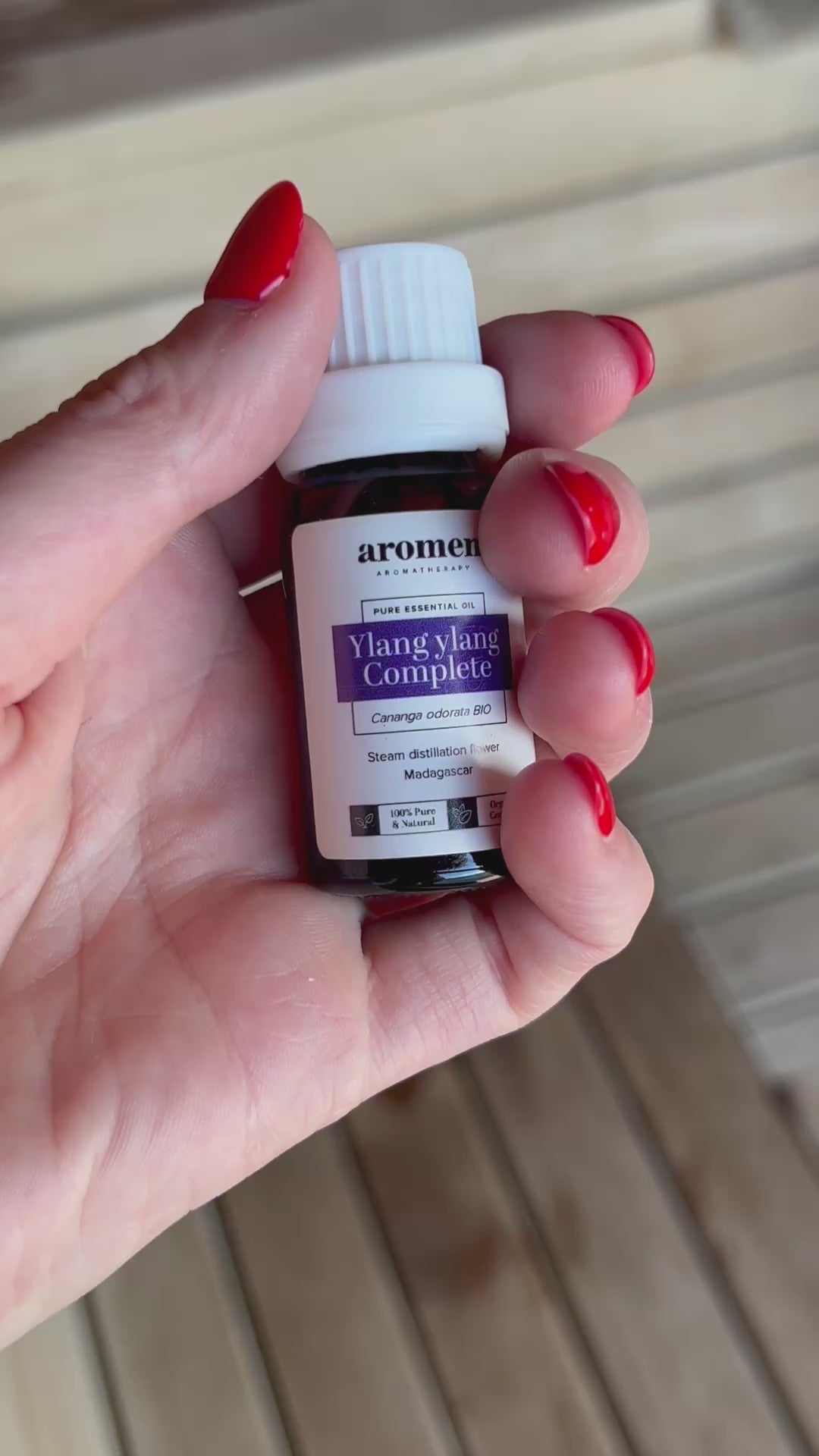 Ylang Ylang Complete eterisk olje fra Aromen holdt i hånd i badstumiljø