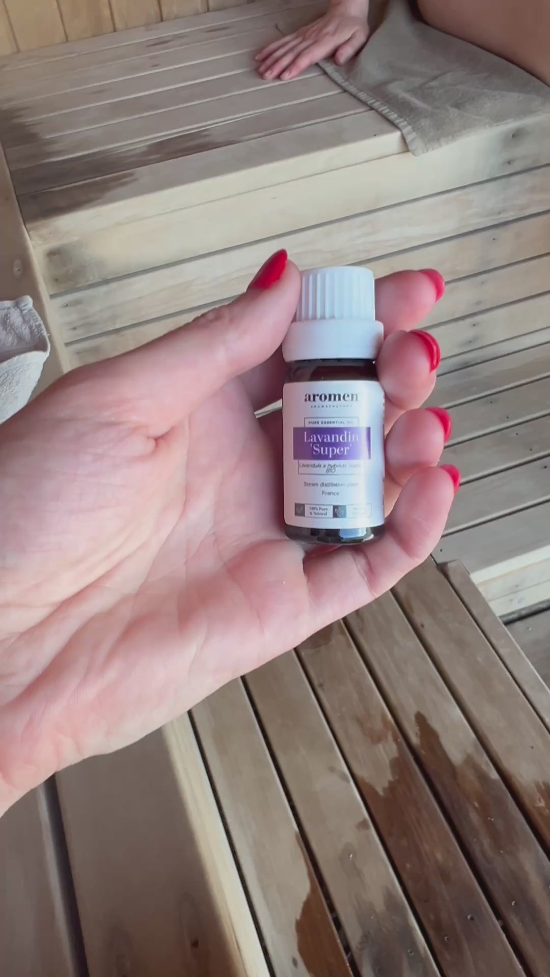 Lavandin Super eterisk olje fra Aromen holdt i hånd i badstumiljø